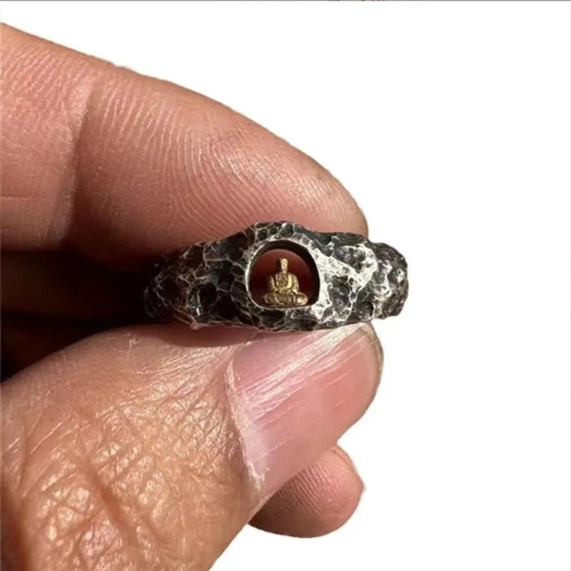 Close-up of a hand-forged copper Grotto Buddha Ring with rock texture, showing the Buddha motif on a size 8 band.