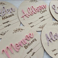 Square wooden newborn name label with baby birth information displayed on plywood