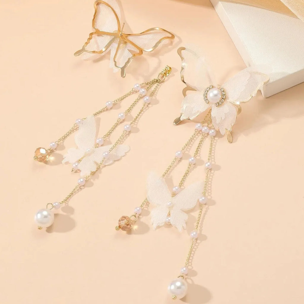 White butterfly earrings with lace detailing, tassels, and rhinestone accents on copper alloy