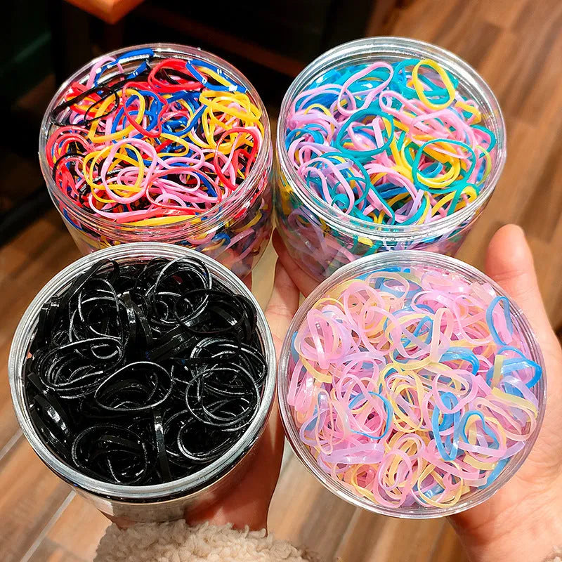 Pack of multicolour TPU baby hair ties for toddlers in a clear reusable container.