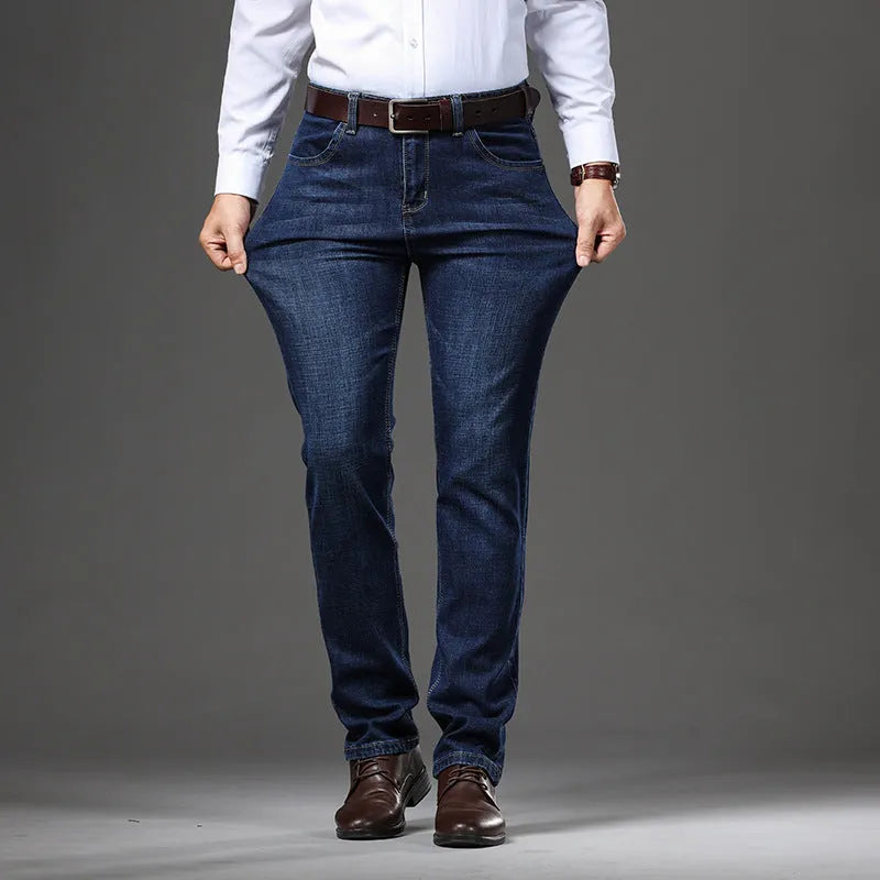Man wearing loose fit straight-leg stretch jeans in blue denim for a business casual look.