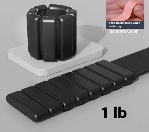 Detachable silicone-padded wrist weight bracelet with Velcro strap in black, showing 1lb and 2lb options.