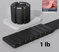 Detachable silicone-padded wrist weight bracelet with Velcro strap in black, showing 1lb and 2lb options.