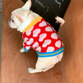 Red heart pattern dog coat with attached scarf on a neutral background