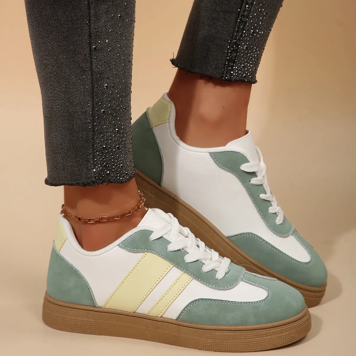 Green women's low-top retro sneakers with white cross straps and stitching on a PU upper.
