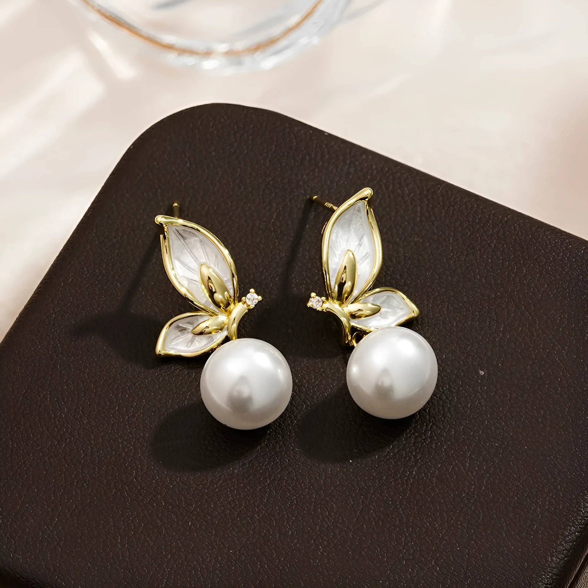 A pair of simple zircon butterfly stud earrings for women with copper electroplated finish.