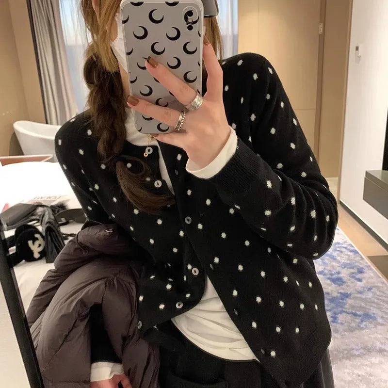 Women's grey knitted cardigan with long sleeves and white crocheted flower details on the front.