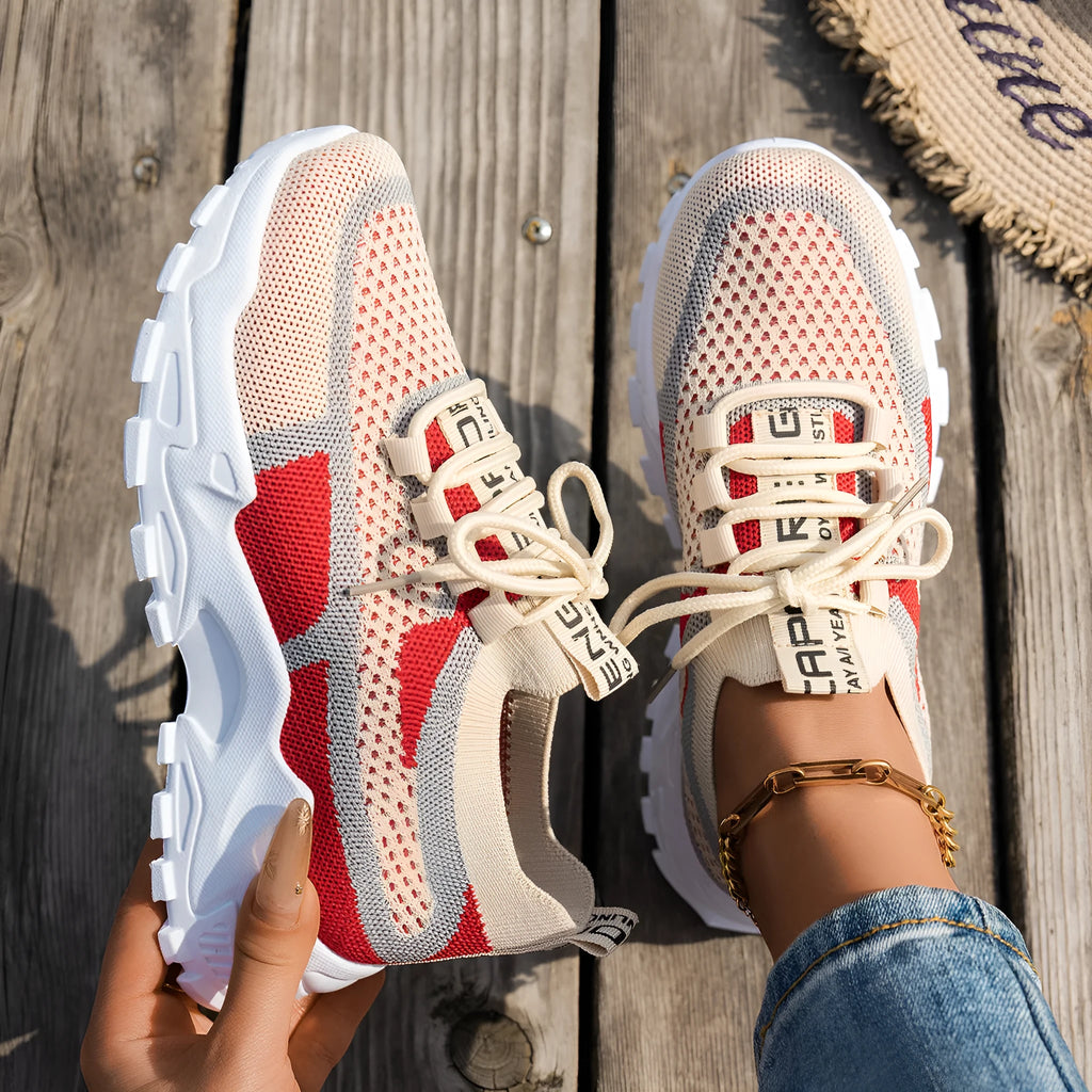Women's Flyknit mesh lace-up sneakers in a grey colourway on a white background.