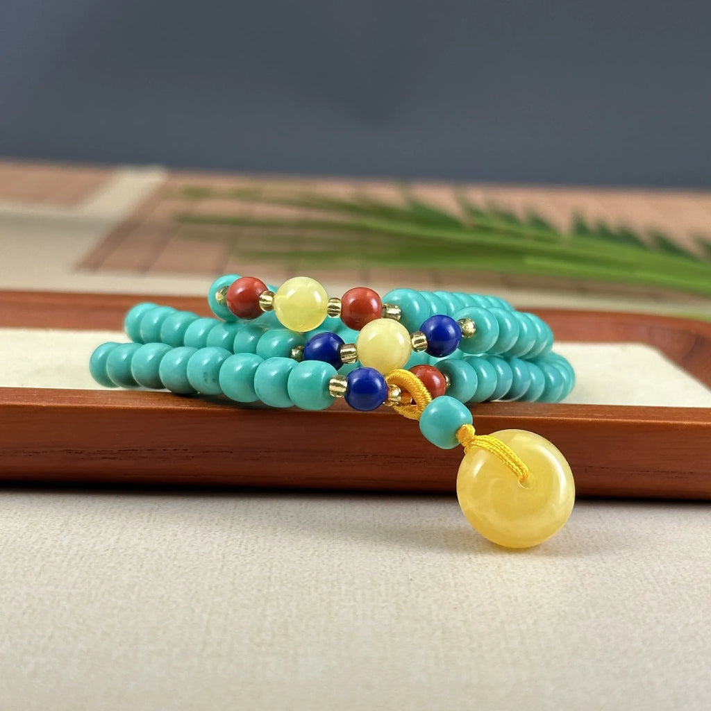 Turquoise lucky pendant necklace with hand-woven mesh flower design on adjustable ball bead chain