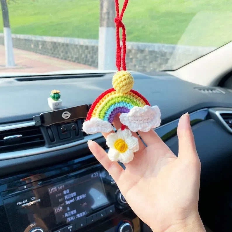 Handmade crocheted car pendant in avocado, pink rainbow, and red rainbow cartoon designs.