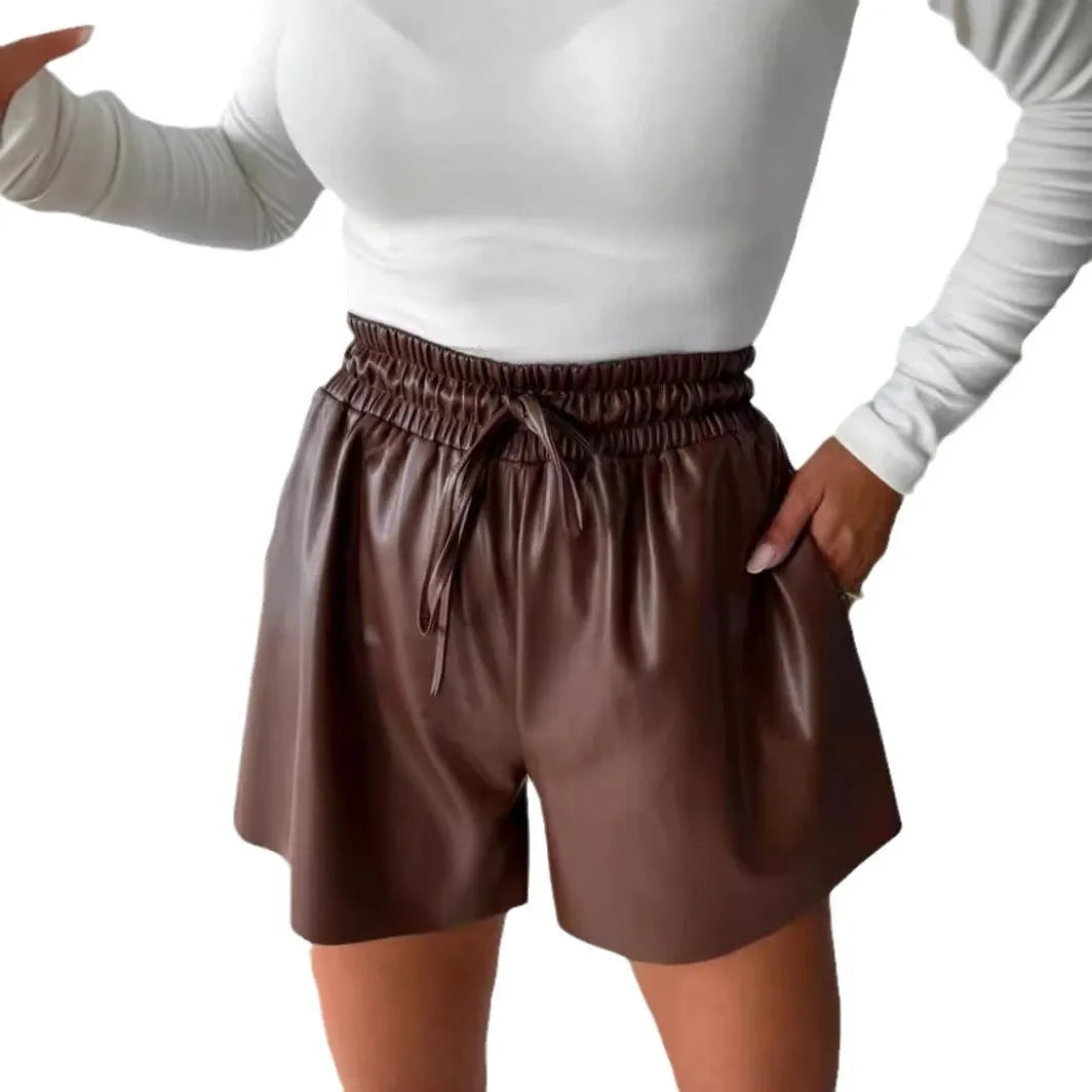 Women's black lace-up PU leather wide-leg casual shorts on hanger showing waist detail and straight-leg silhouette