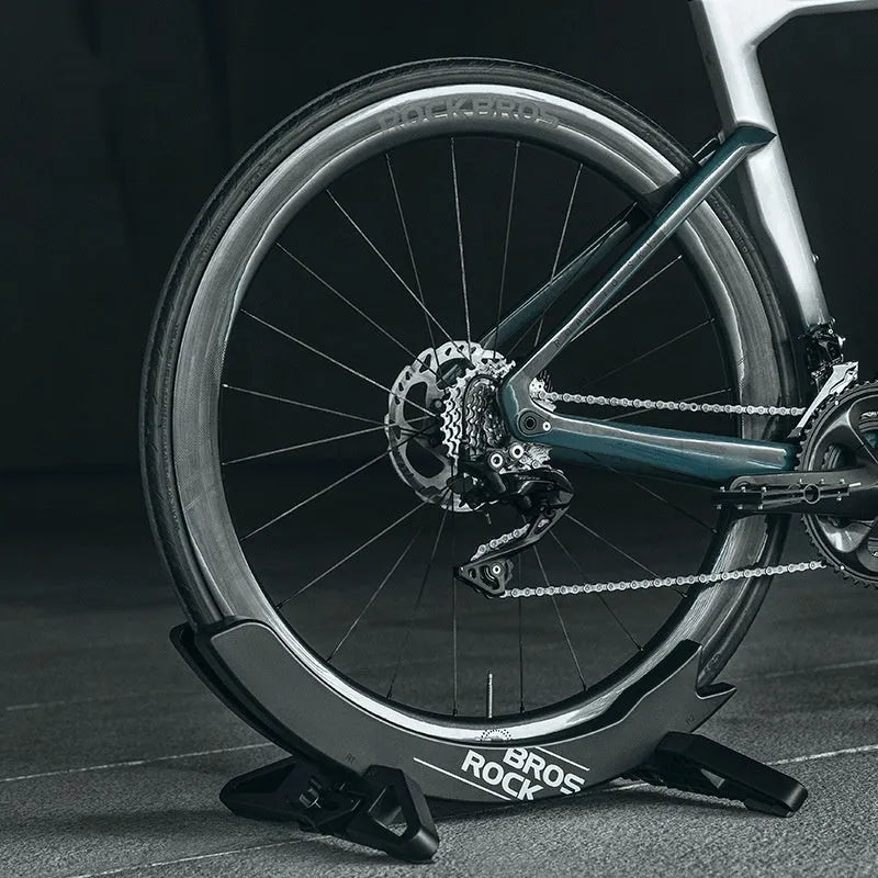 Black and green ABS plastic bicycle parking rack holder with fixed mounting bracket.