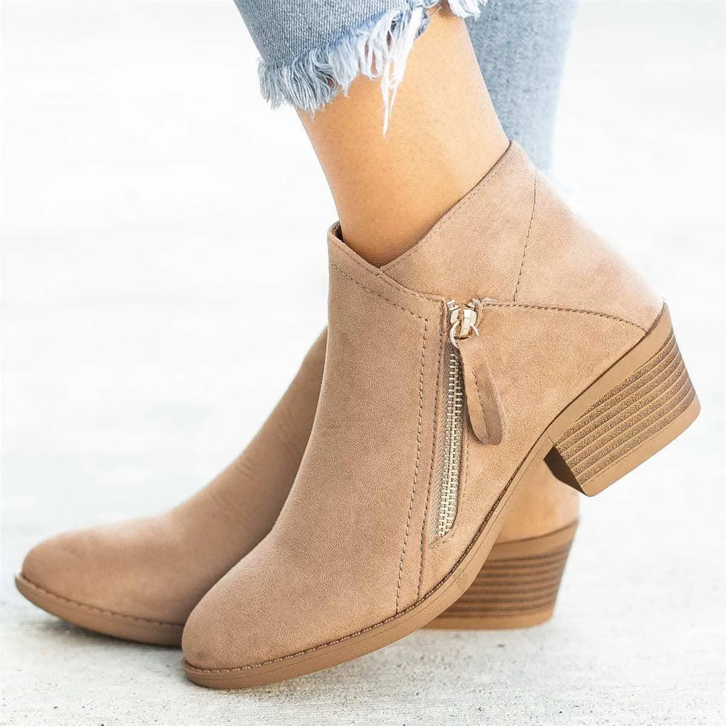 Blue suede Dr. Martens ankle boots with side zip and chunky heel on a white background.