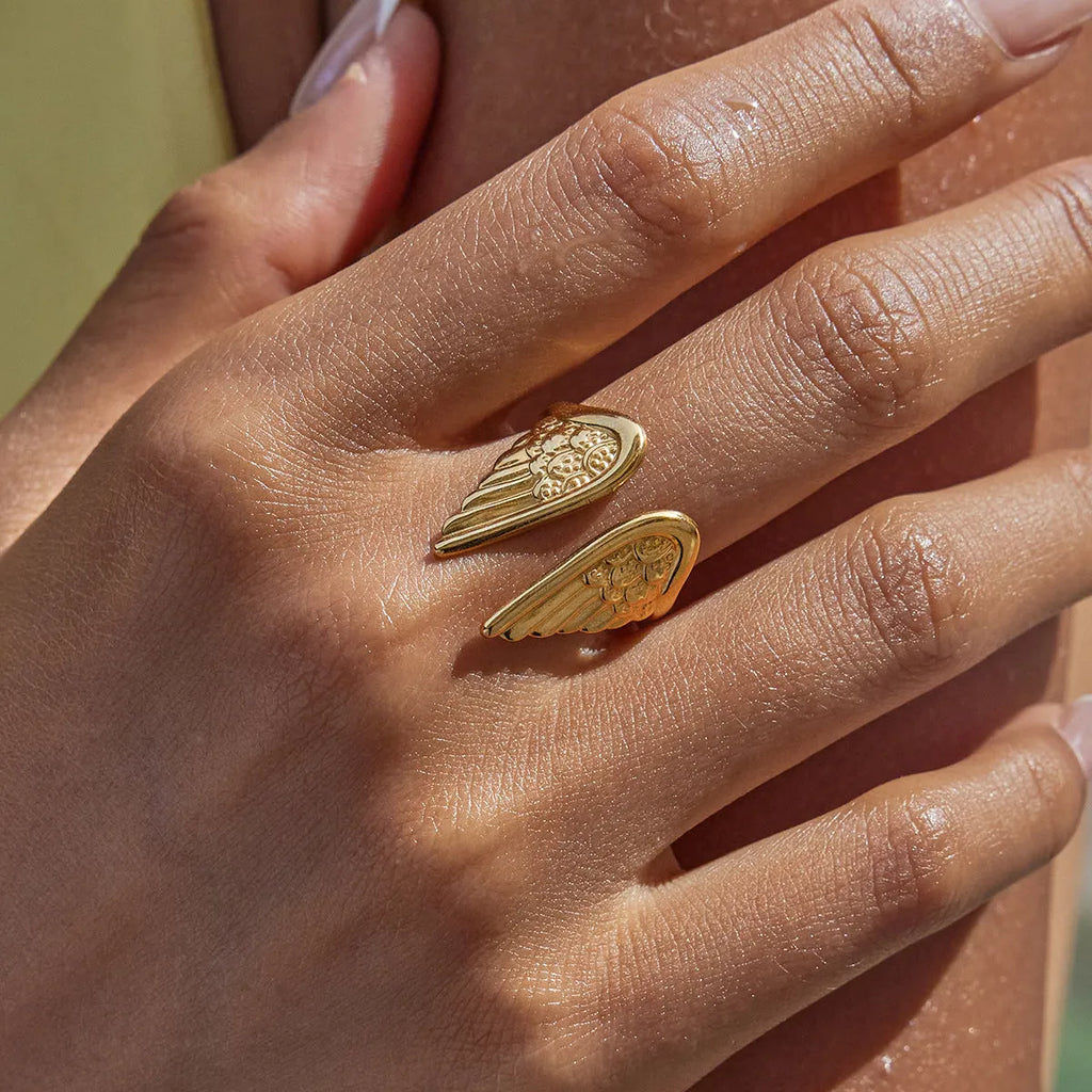 Adjustable stainless steel wings ring with an opening clasp in an electroplated colour finish.