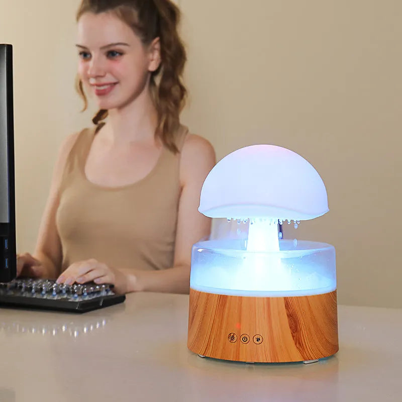White cloud-shaped humidifier emitting mist with LED lights and falling water droplets