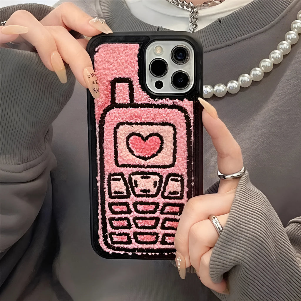 Pink towel embroidered soft TPU back cover case for iPhone models on a table.