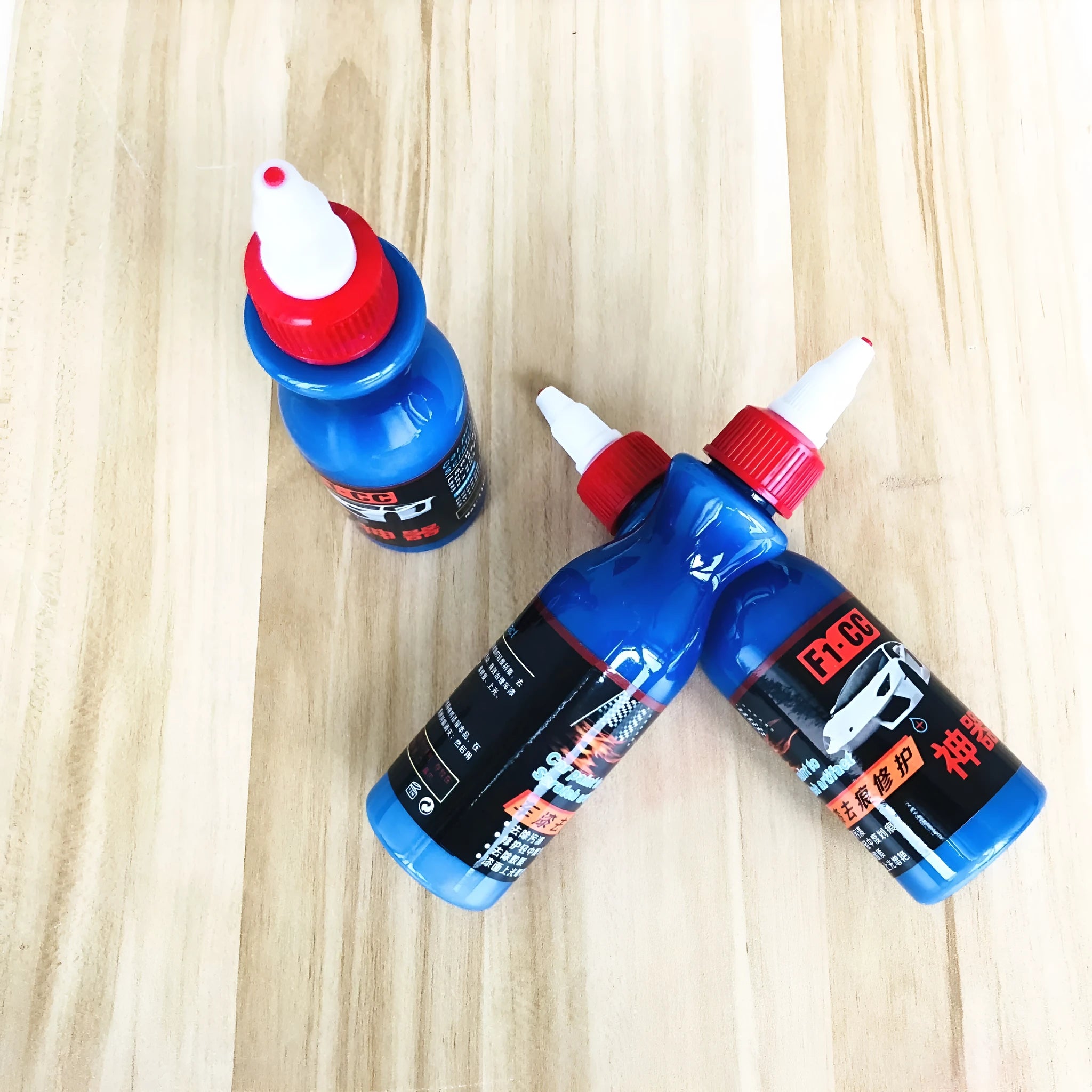 Small blue automotive scratch repair kit with repair agent bottle and applicator sponge for car paint damage