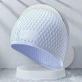 Solid colour silicone swimming cap for adults shown in multiple fashion colours.
