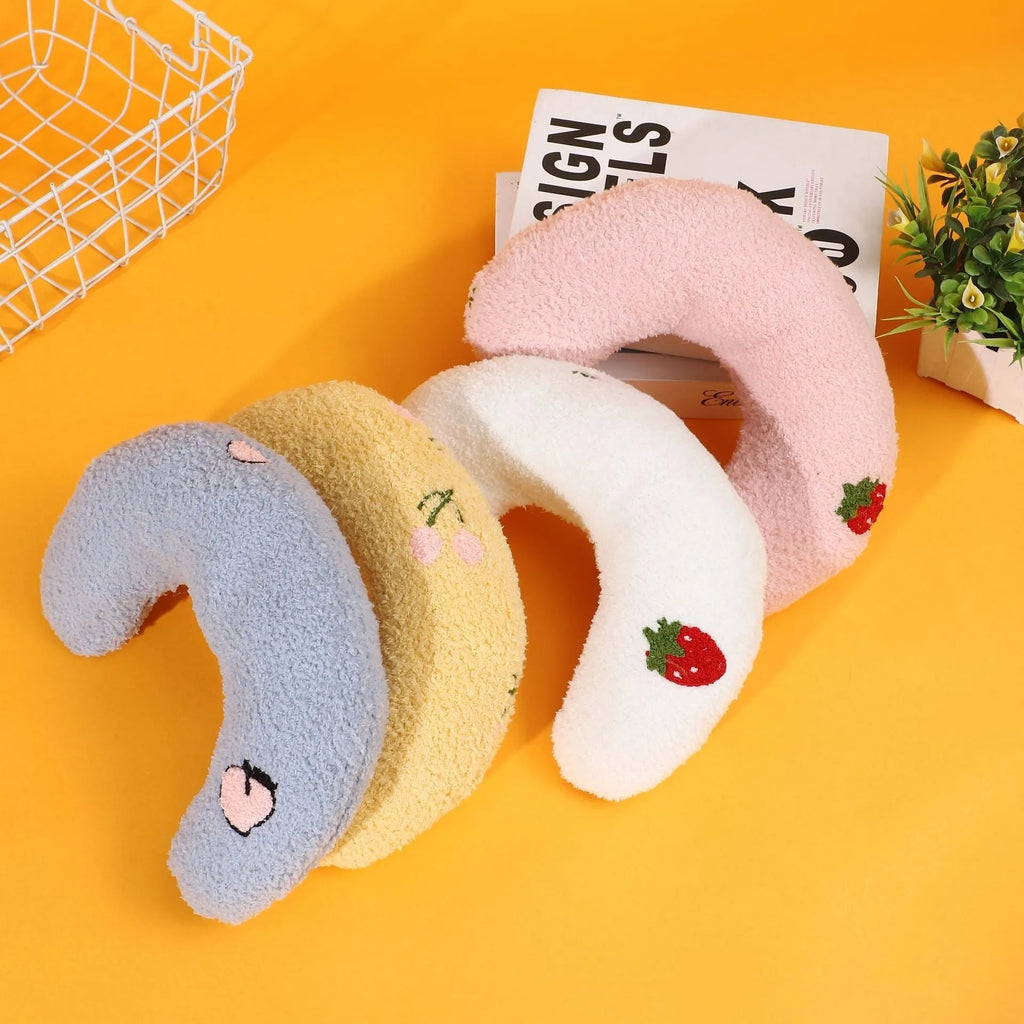 Blue U-shaped half moon cartoon pet pillow for a cat or small dog on a floor.