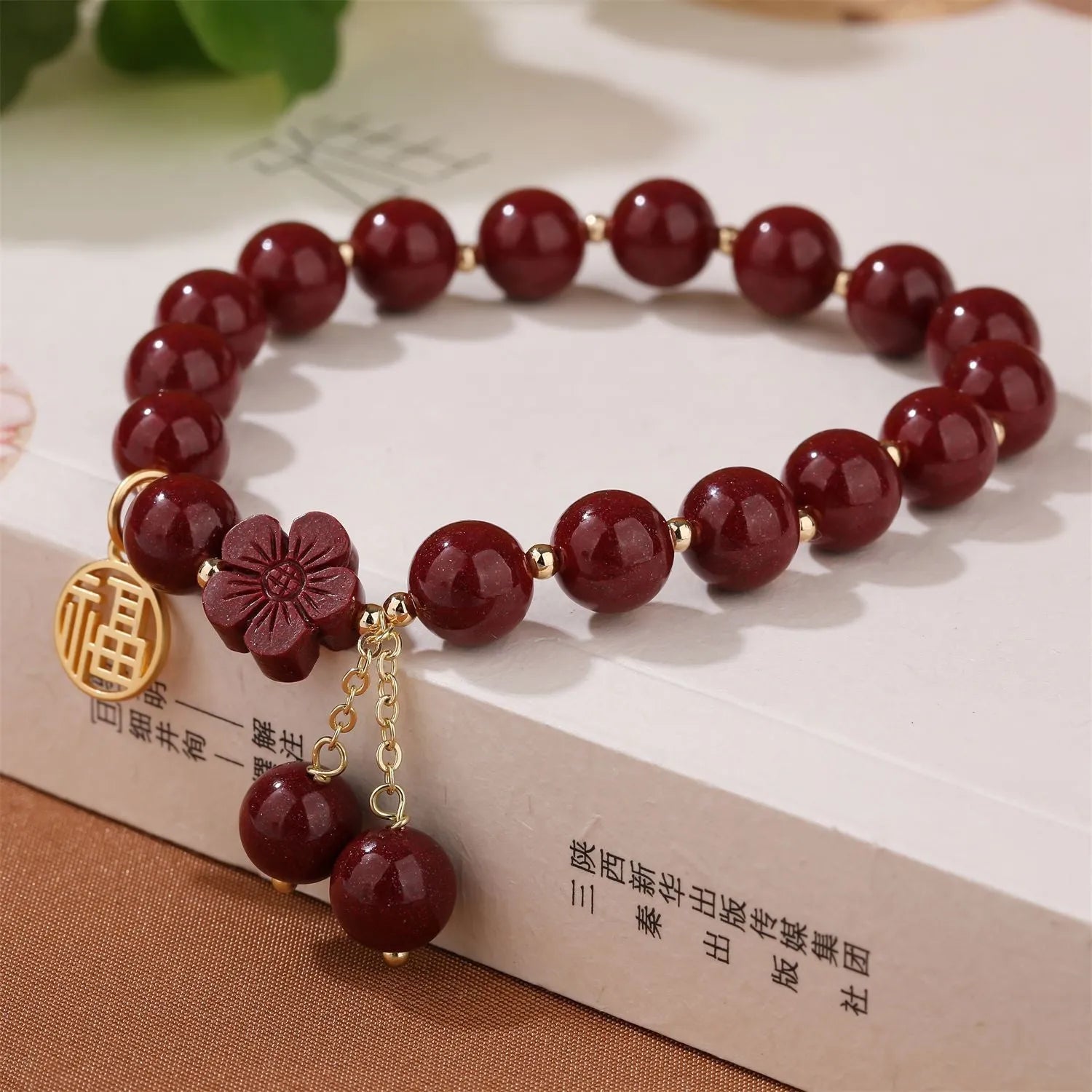 Close-up of a purple gold sand cinnabar bracelet with a fu character charm and adjustable tassel.