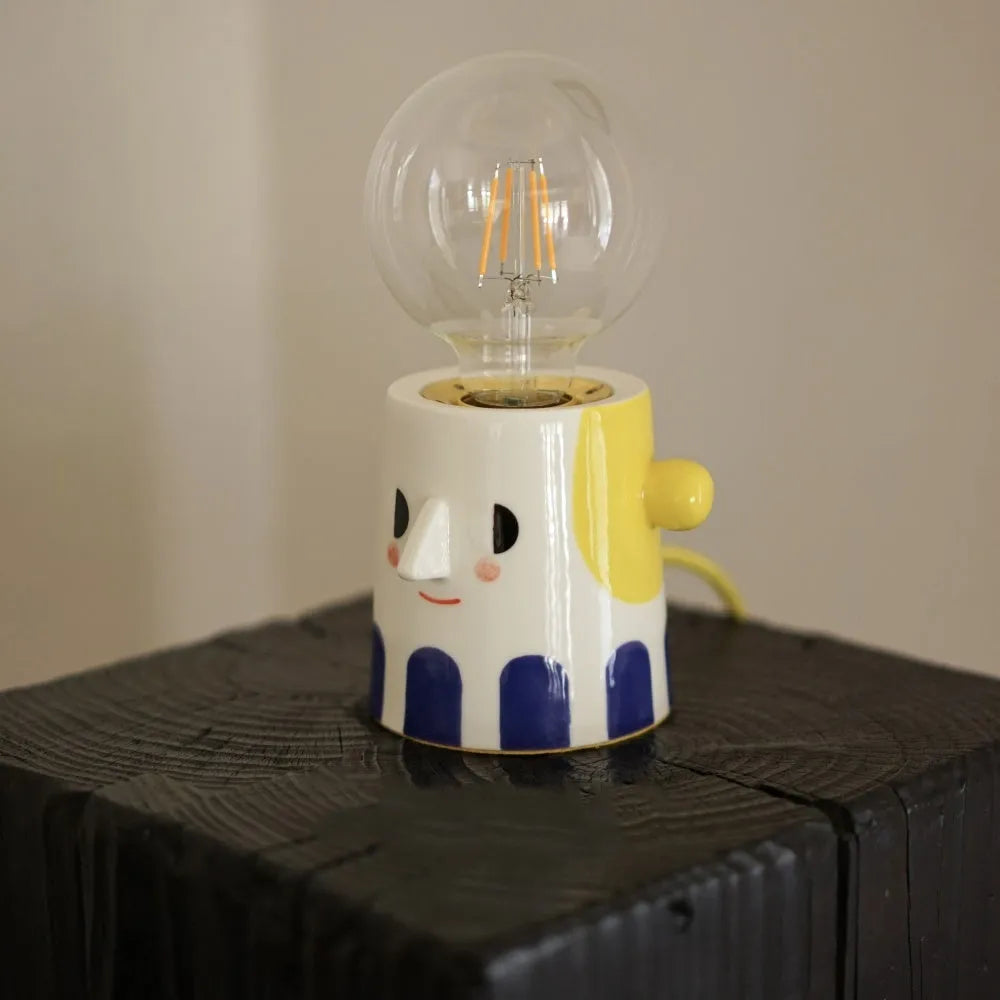 Handmade ceramic lamp with ball headlight design on bedside table