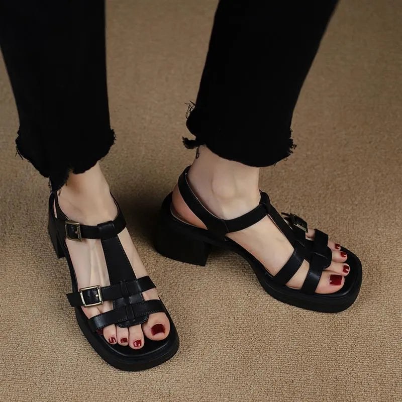 Women's black retro platform sandals with a T-shaped buckle strap and chunky heel.