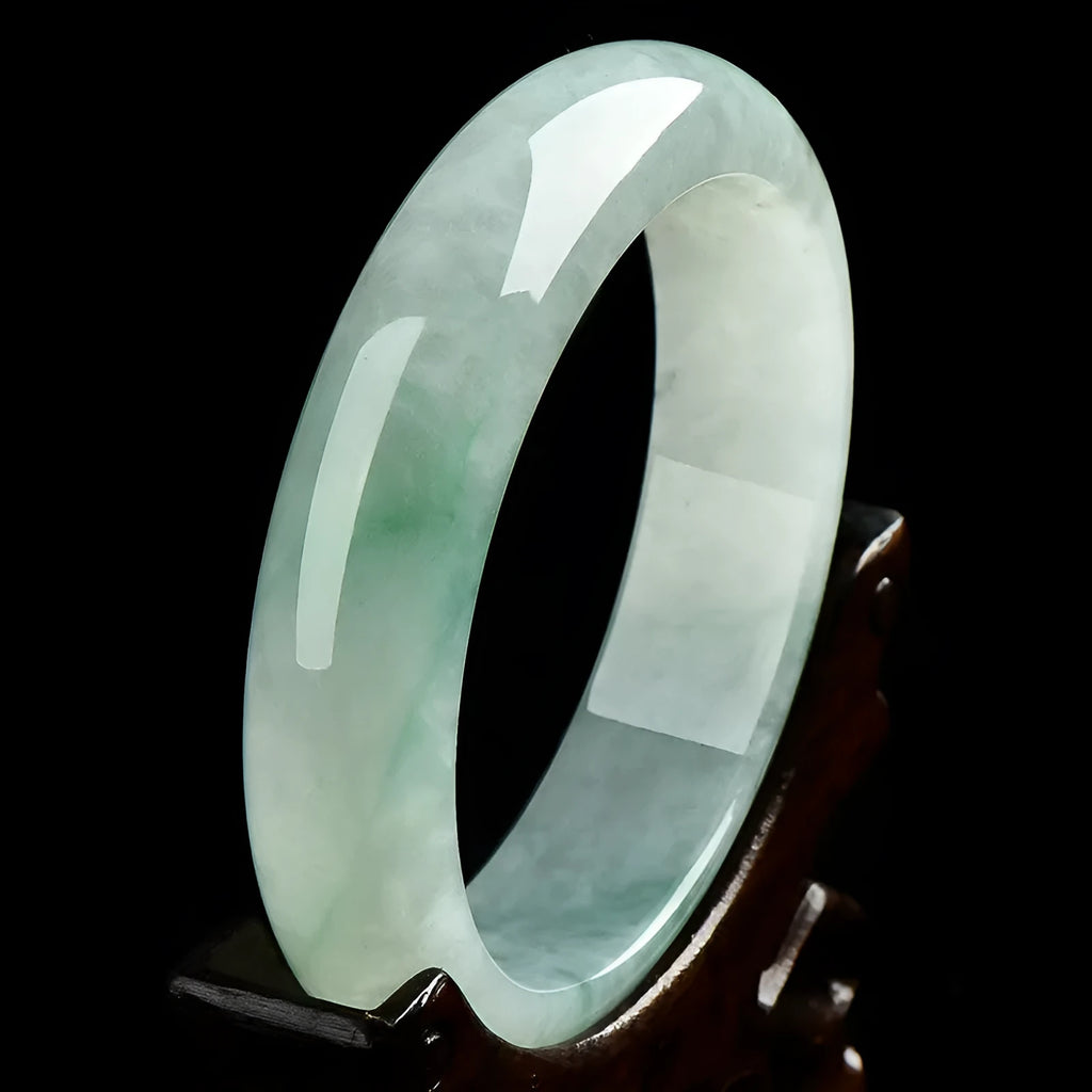Natural light green jade bracelet on a wrist, showing unisex design and stone detail.
