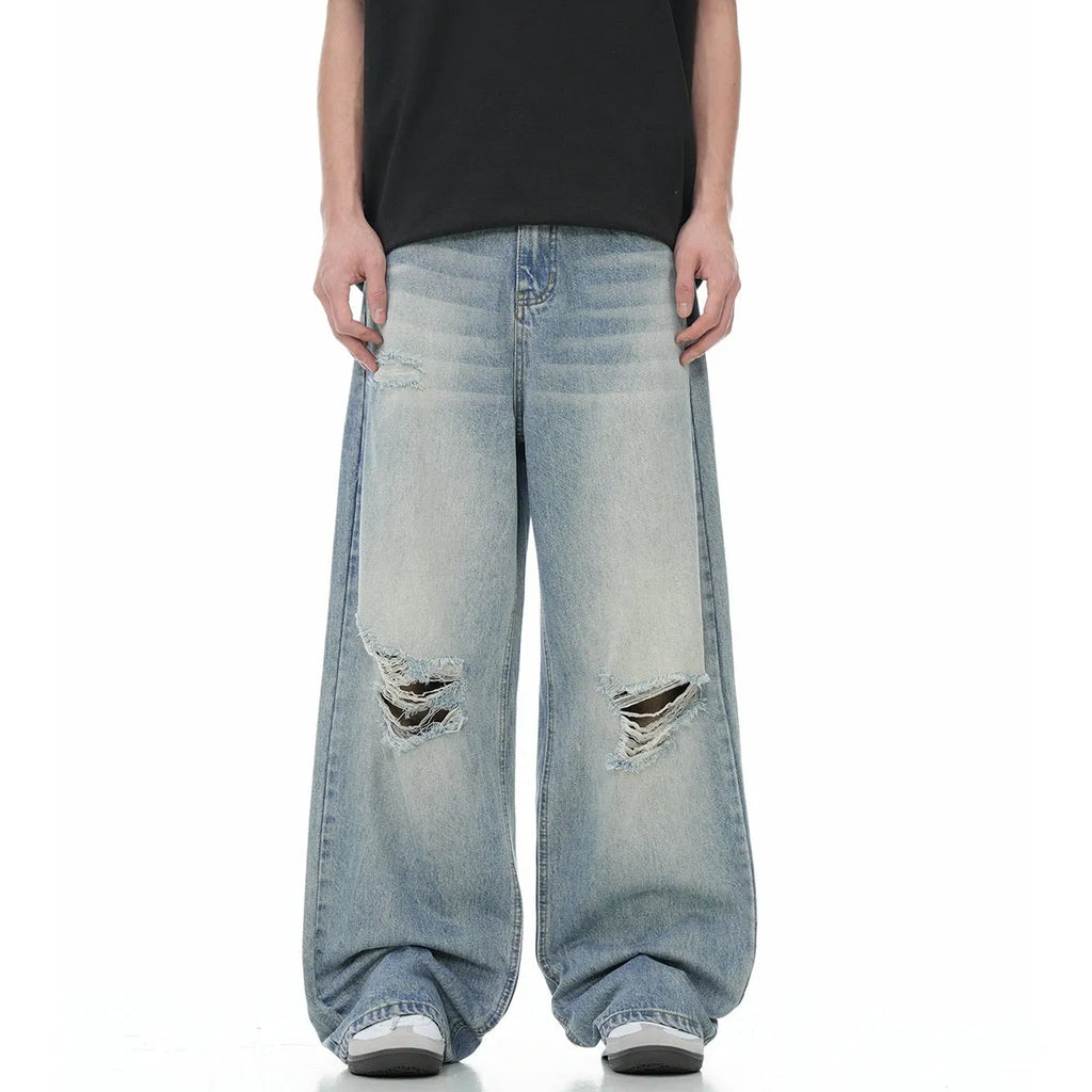 Blue men's straight-leg ripped jeans on a neutral background, showing the cotton blend fabric and zipper fly detail.