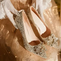 Champagne coloured women's wedding shoes with crystal rhinestones and a pointed toe, shown with a high heel.