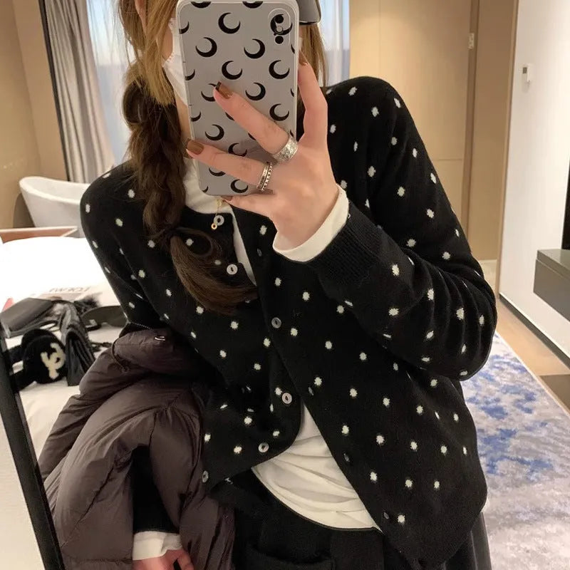 Women's grey knitted cardigan with long sleeves and white crocheted flower details on the front.