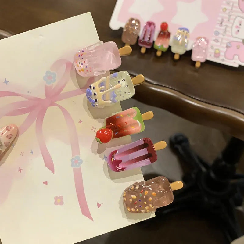 Close-up of a resin hair clip with a colourful cartoon ice cream design, shown in beige.
