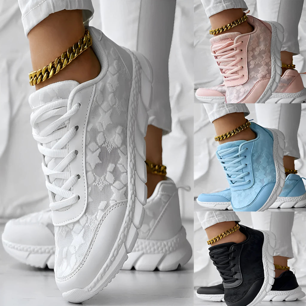 Women's white canvas sports shoes with round toe and flat heel on a neutral background.
