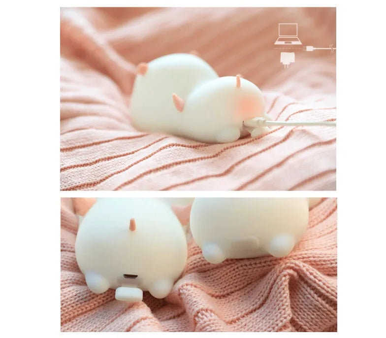 Cute pig silicone night light in Pink with sleeping face design on a wooden table