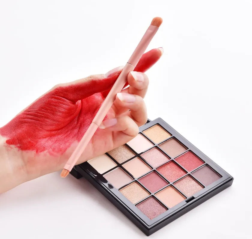 Ten professional makeup brushes with wooden handles in a pink box, including powder, foundation, and double-ended brushes.