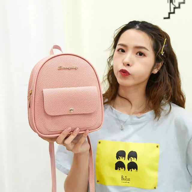 Small black PU shoulder backpack showing front zipper and dimensions