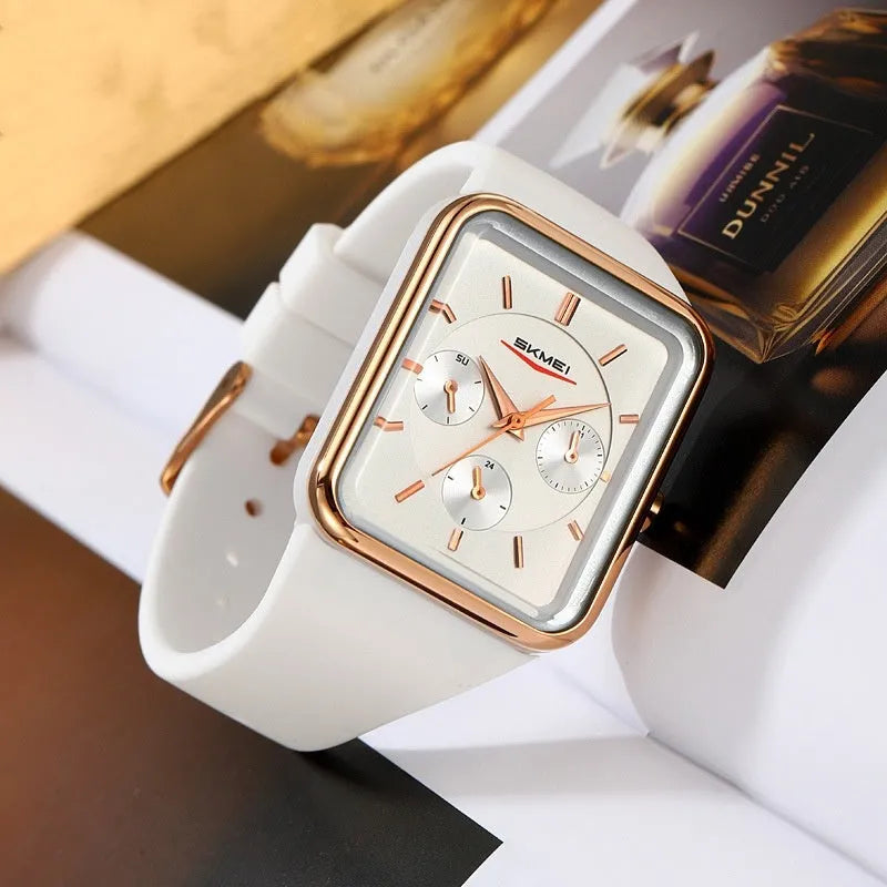 Square analogue silicone watch for women in white rose gold colour on a wrist, showing slim profile.