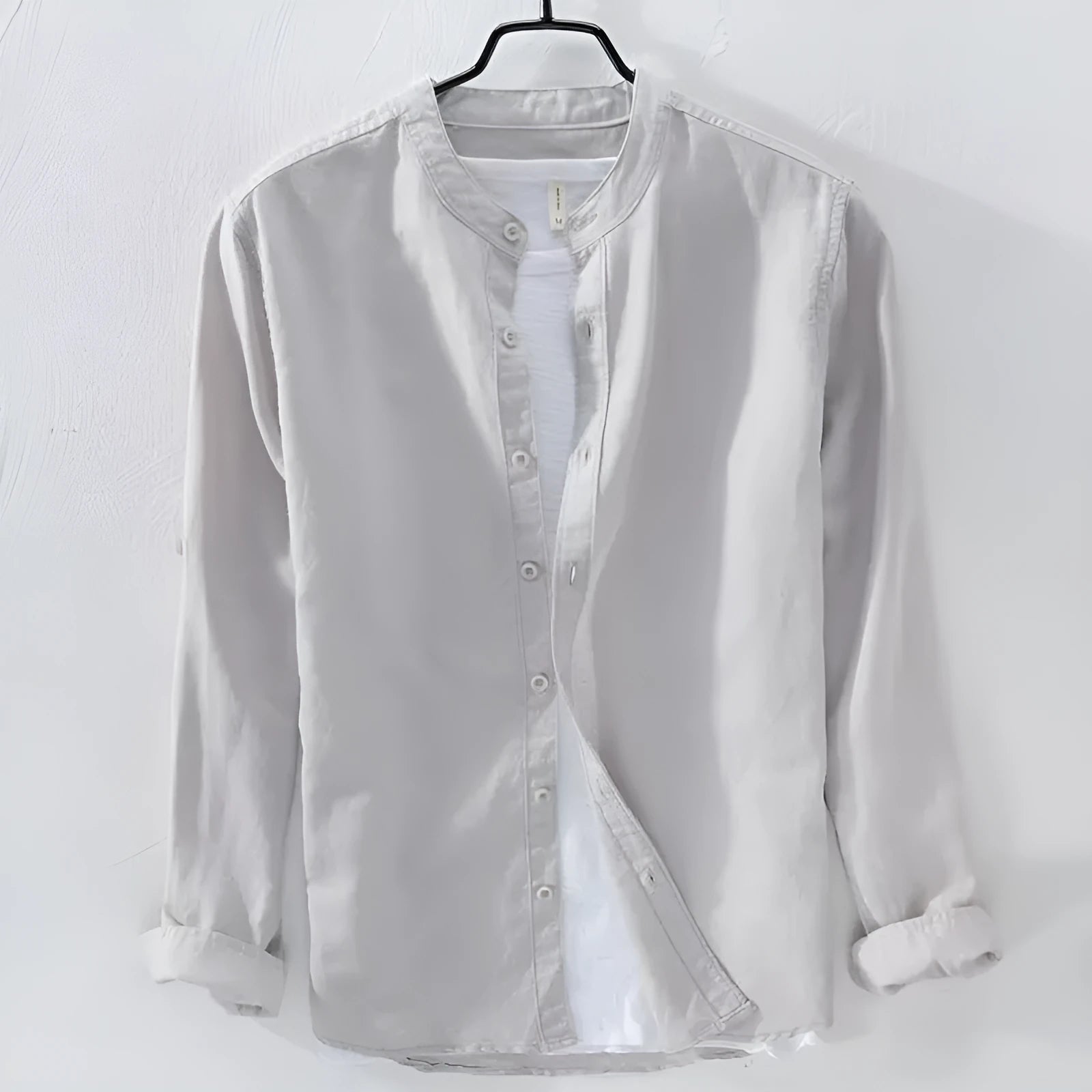 Loose fit long sleeve linen shirt in solid colour on hanger showing casual collar and button front