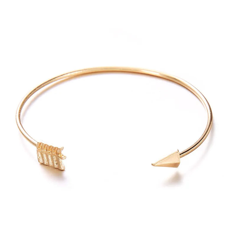 Gold electroplated alloy women's cuff bracelet with vintage arrow and knot design.