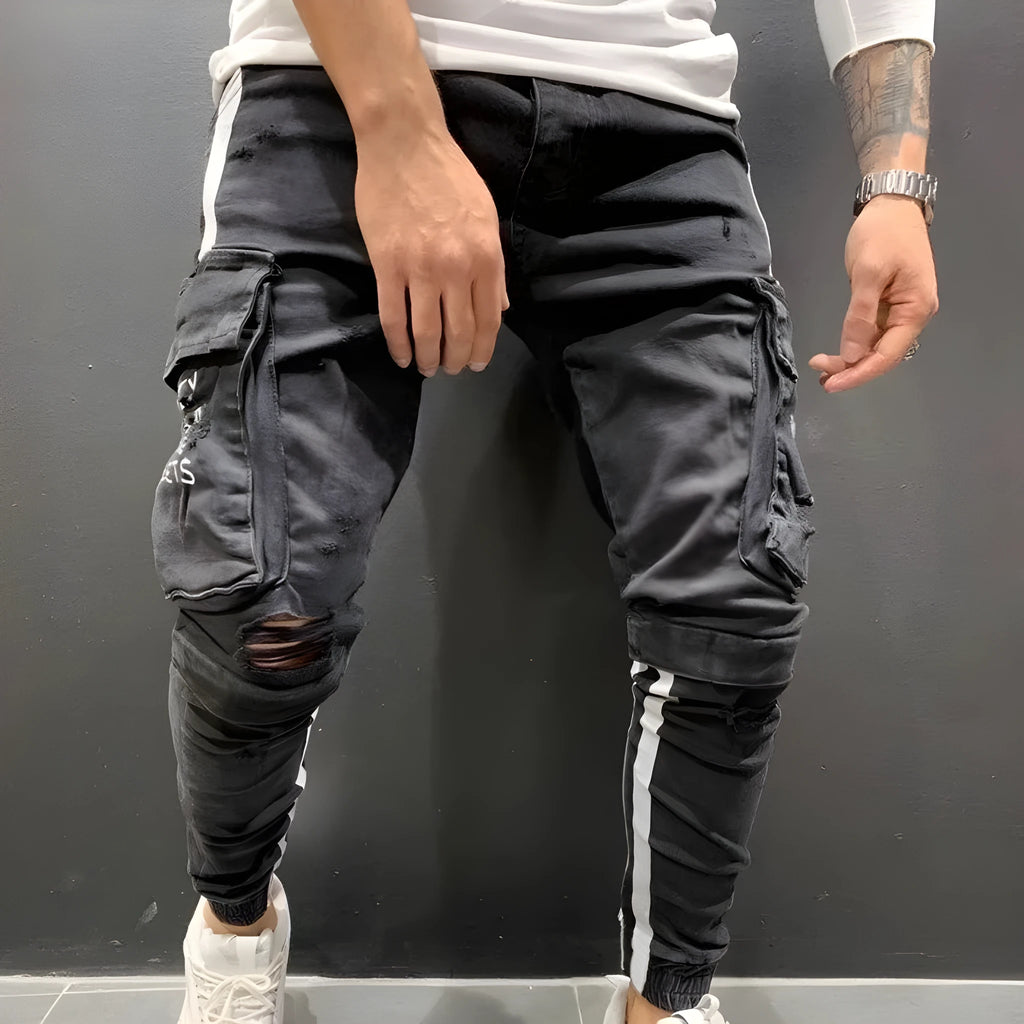 Men's denim knee-cut zipper trousers in black, front view, showing zipper placket and relaxed fit