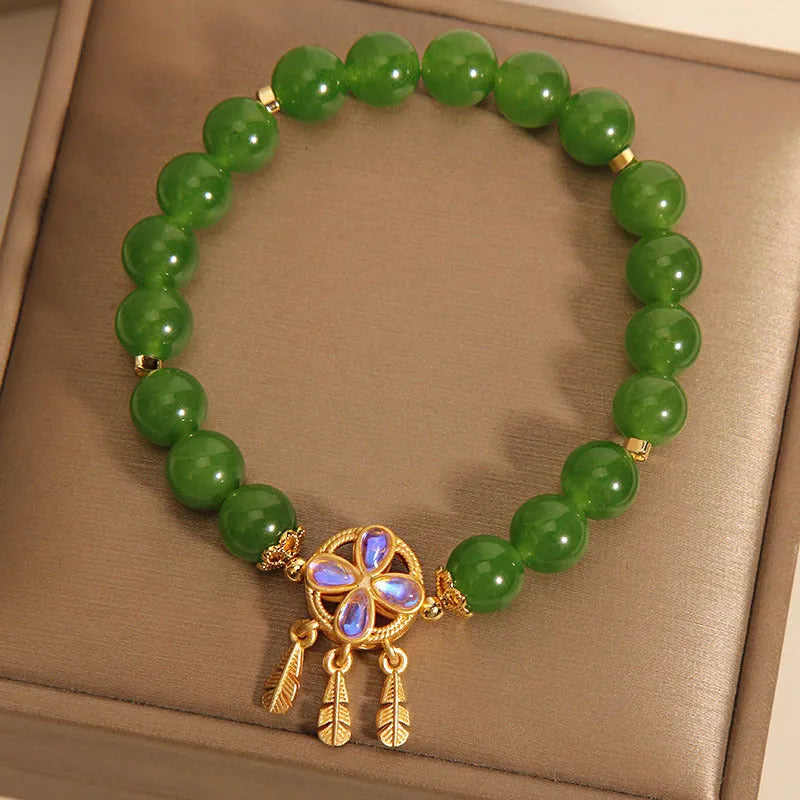 Green jasper bracelet for women with a four-leaf clover dream catcher crystal pendant on a chain.