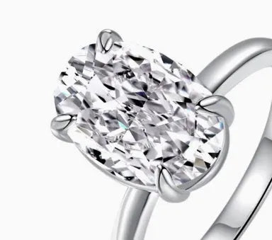 Oval sterling silver women's ring with four-claw setting and hand-cut gemstone.