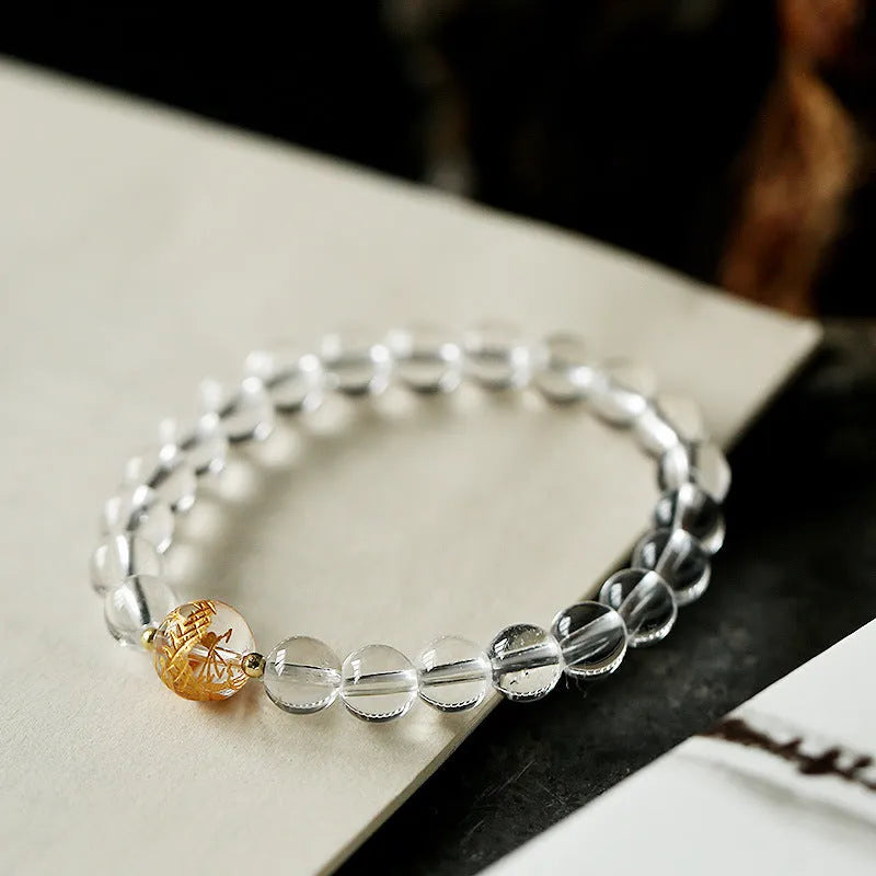 Unisex geometric beaded bracelet with obsidian, white crystal, and a gold dragon bead on a black background