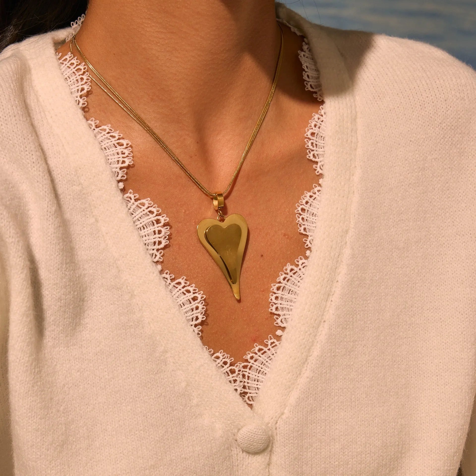Geometric double heart pendant on a textured snake bones chain necklace in gold or steel finish.