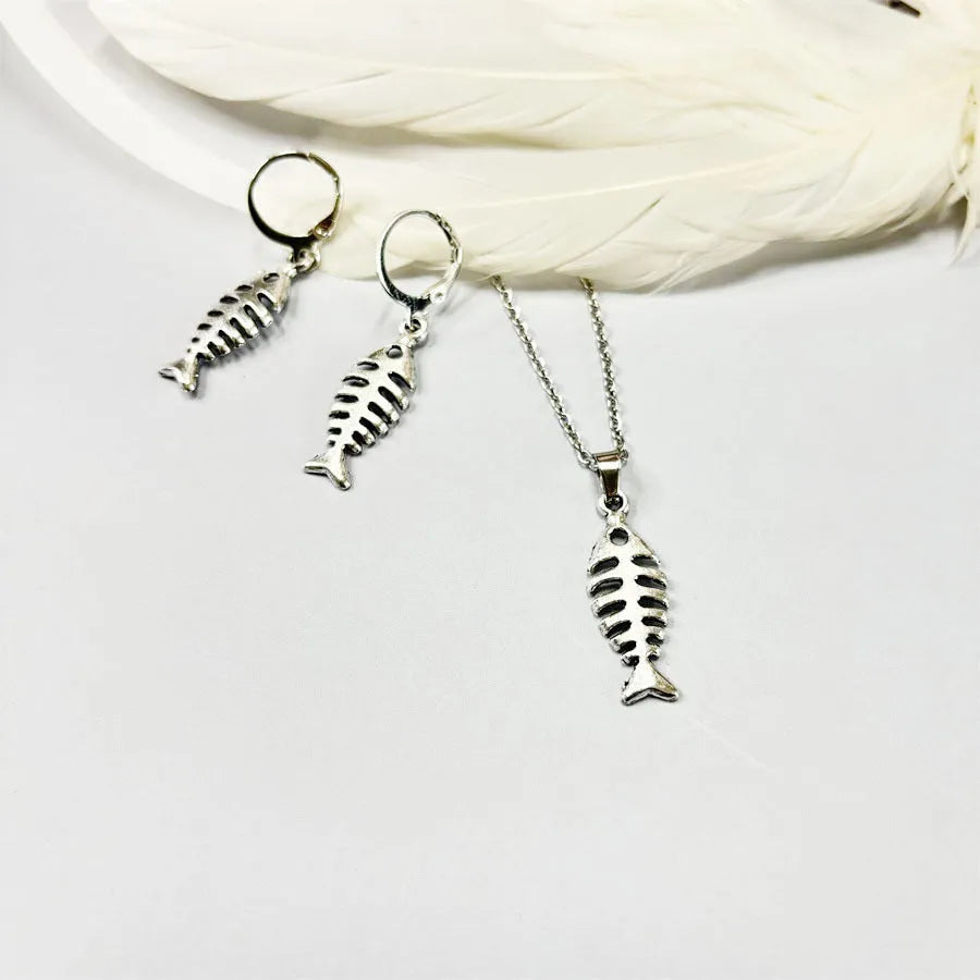 Fishbone pendant earrings and matching necklace set with adjustable chain on grey background