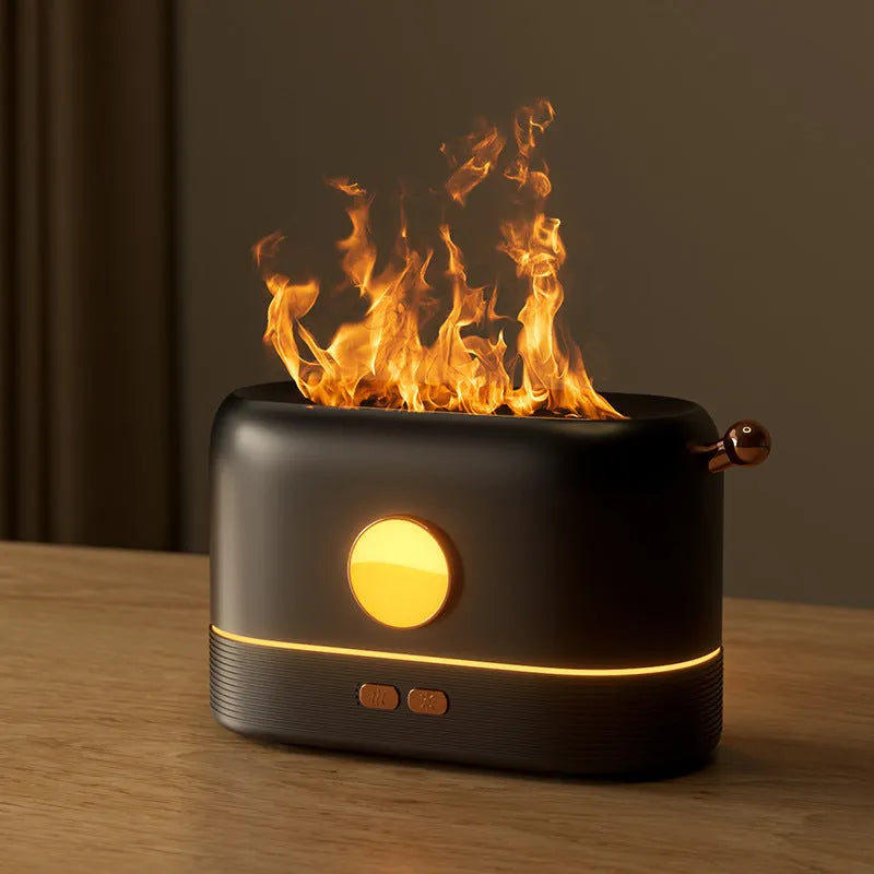 Black USB desktop humidifier with LED flame effect and water tank on a wooden desk.