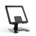 Flat black metal foldable notebook bracket with rotating base on a wooden desk