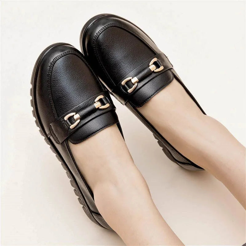 Black women's soft leather casual pumps with a low flat heel and round toe.