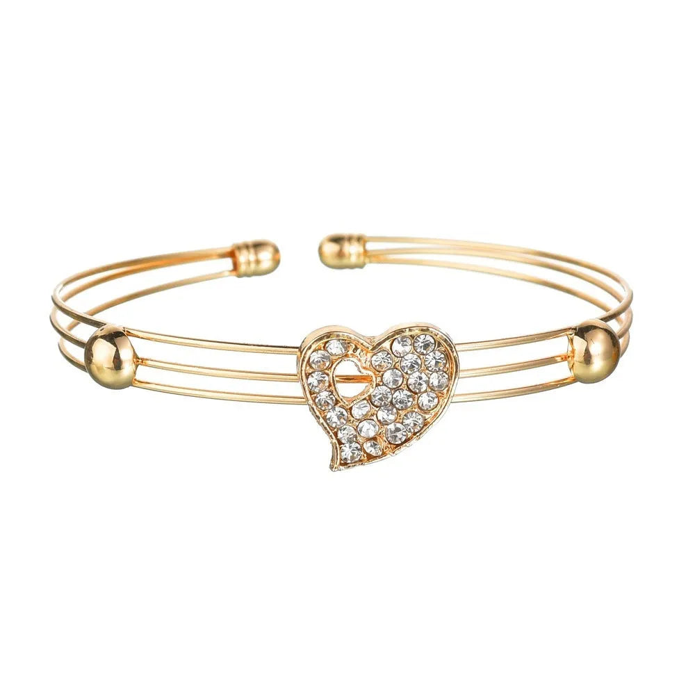 Gold alloy jewellery set with love, water drop and bell charms including earrings, pendant and bracelet
