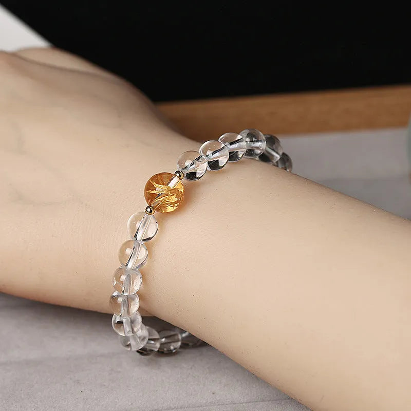 Unisex geometric beaded bracelet with obsidian, white crystal, and a gold dragon bead on a black background