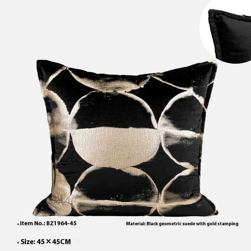 Black and gold abstract pattern flannel pillow cover on a grey sofa.